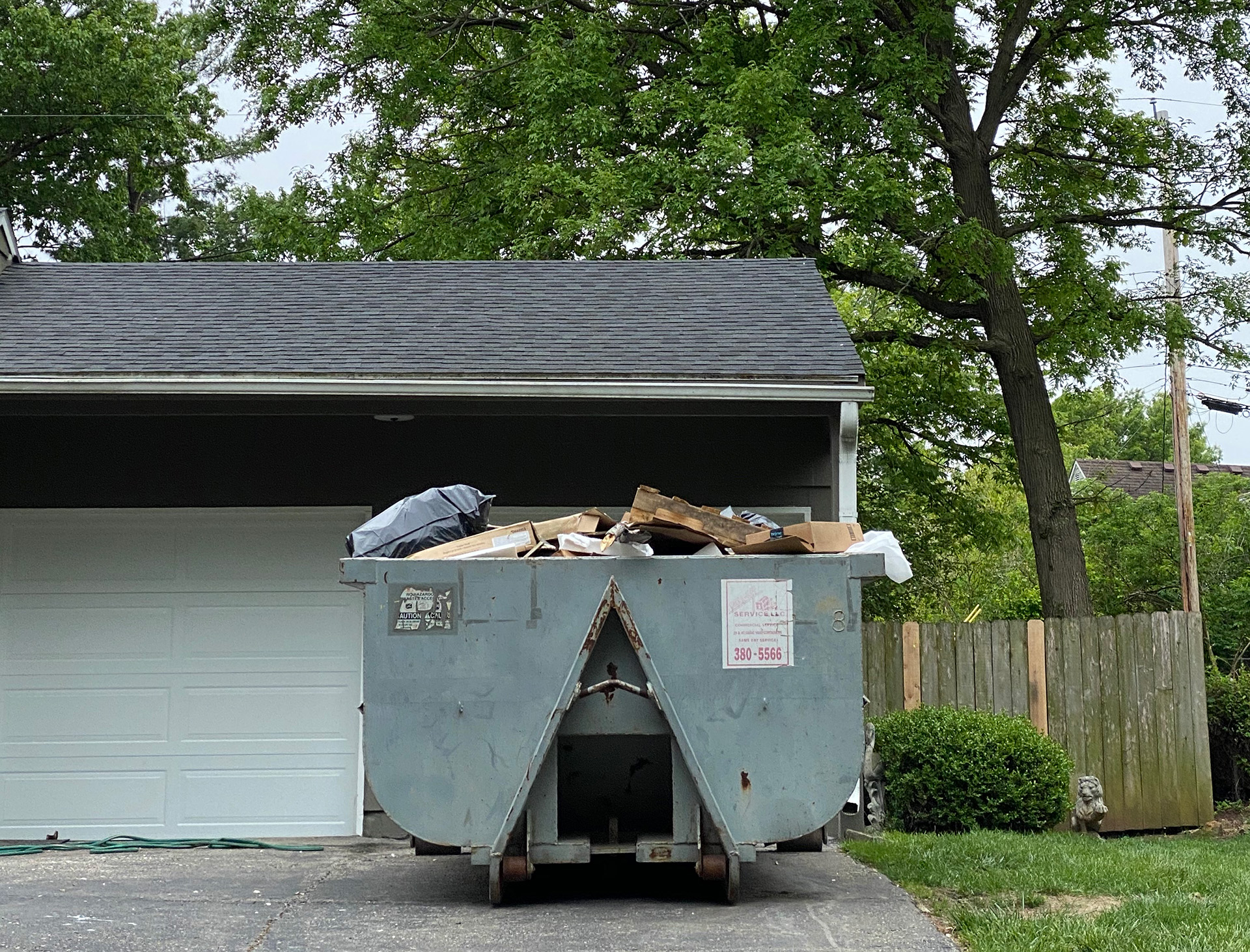 A dumpster sits in the driveway of a home during a remodel