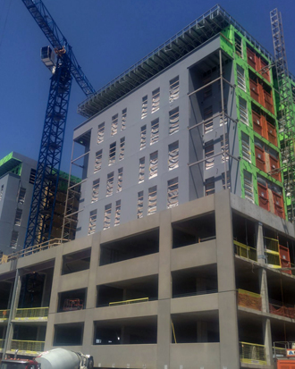 Construction site of a multi-story commercial building with crane, showcasing exterior framing and materials, relevant to Nastase Contracting's services in commercial exteriors and new construction projects.