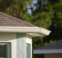 Residential gutter system installed on a home, showcasing roof edge and fascia, emphasizing water drainage importance for home protection.