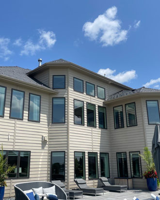 Modern residential exterior featuring multiple large windows and siding, showcasing quality craftsmanship by Nastase Contracting in Omaha.