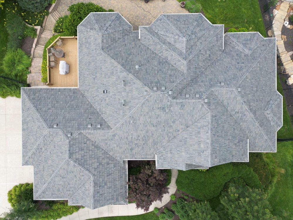 Aerial view of a residential roof featuring Brava Shake tiles in Canyon Gray, highlighting the intricate design and surrounding landscaping in Omaha, NE.