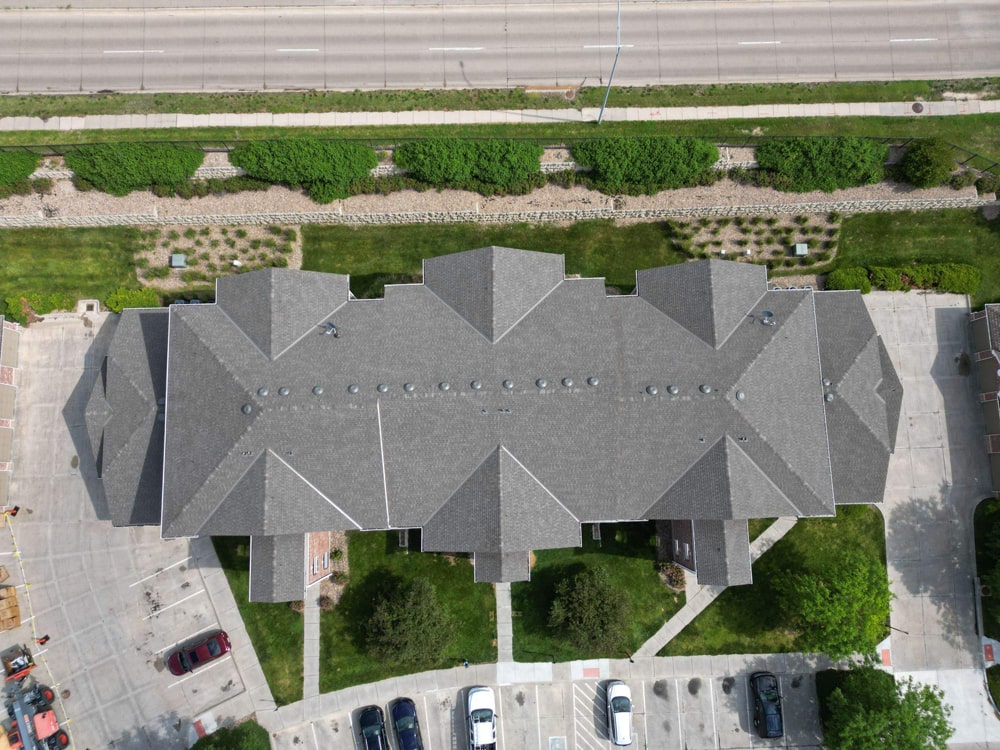 Aerial view of Cimarron Terrace multifamily apartment complex in La Vista, NE, showcasing the newly installed Class 4 Impact Rated shingle roof and surrounding landscaping.