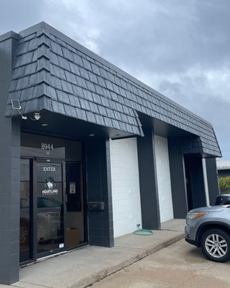 Exterior view of a commercial building featuring a slate-style roof, modern architectural design, and a prominent entrance, relevant to specialty commercial exteriors services.